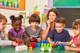 Group of children plays together in daycare with an educator