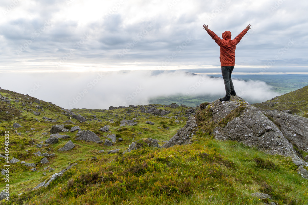 Man with raising his arms triumphant in mountain of Ireland Man with raising his arms triumphant in mountain of Ireland
