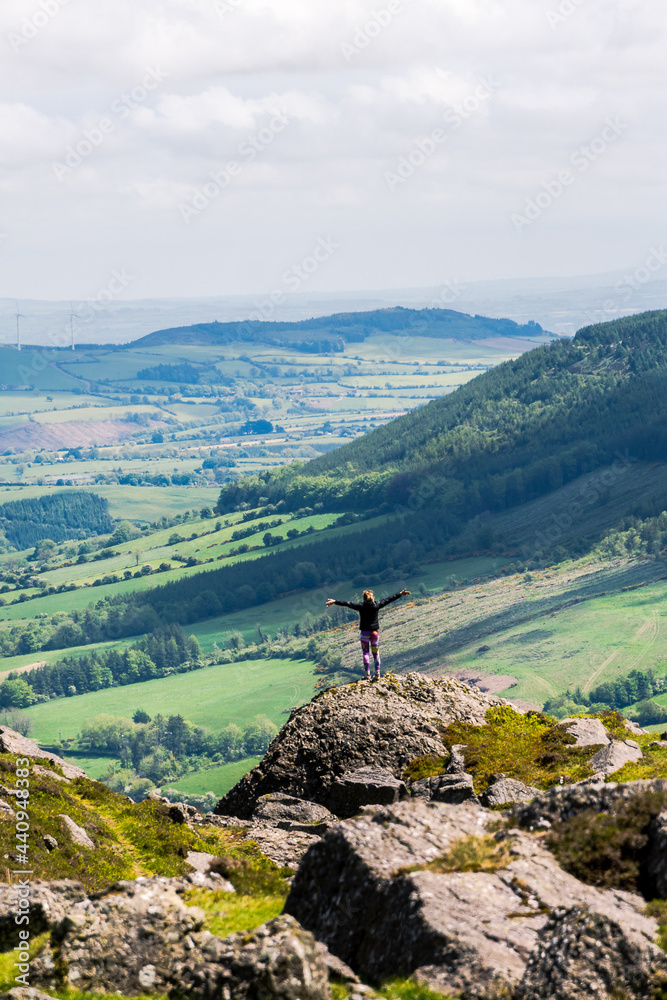 Woman with raising his arms triumphant in mountain of Ireland Woman with raising his arms triumphant in mountain of Ireland
