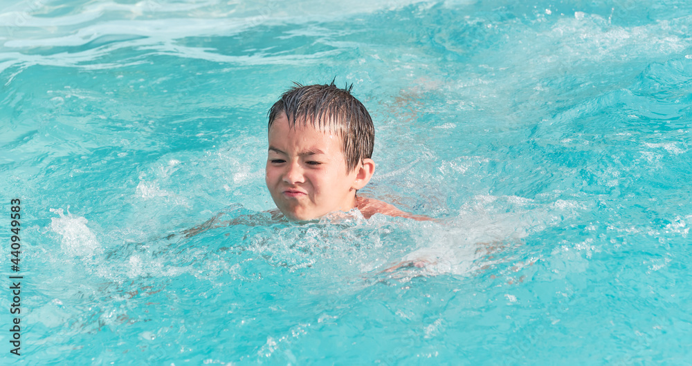 Asian boy is swimming in pool on summer day. Asian boy is swimming in pool on summer day.