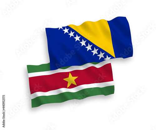 National vector fabric wave flags of Republic of Suriname and Bosnia and Herzegovina isolated on white background. 1 to 2 proportion.