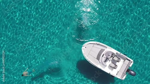 Aerial - Couple dives from a boat into beautiful turquoise sea at the same time
