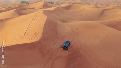 AERIAL. Hight flight above car. Desert safari car sand dunning in the Dubai desert during sunset © skymediapro