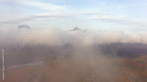 Wallpaper Mural 4k drone footage. Aerial view of camera going above autumn forest with low clouds. Foggy day at Kamchatka peninsula. Volcanoes on the background. Tourism Torontodigital.ca