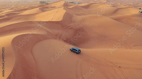 AERIAL. Hight flight above car. Desert safari car sand dunning in the Dubai desert during sunset © skymediapro