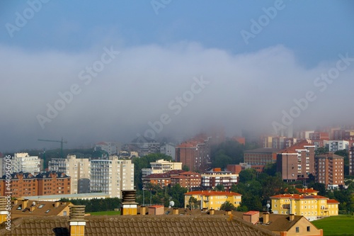 Panoramic view across rooftops with apartment buildings shrouded in sea fog Santander Cantabria Spain June 2021 photo