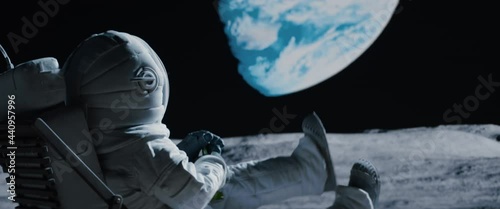 Back view of lunar astronaut having a beer while resting in a beach chair on Moon surface, enjoying view of Earth. Shot with 2x anamorphic lens photo