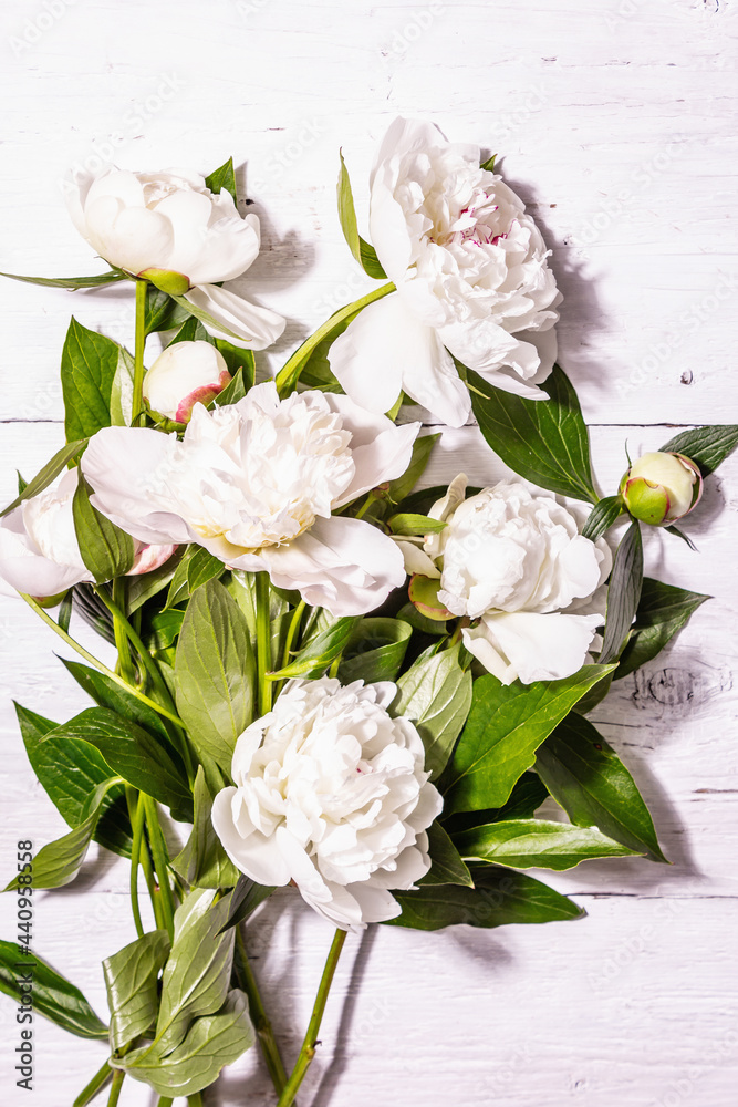 Bouquet of fresh white peonies on white old planks background