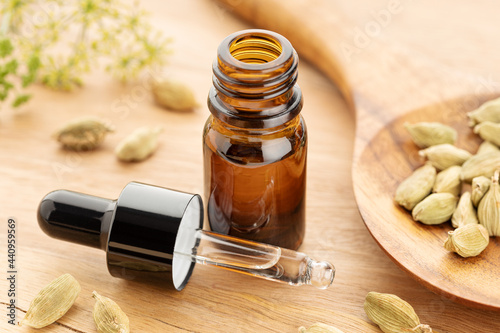 Cardamom essential oil on bottle on wooden table. Alternative medicine