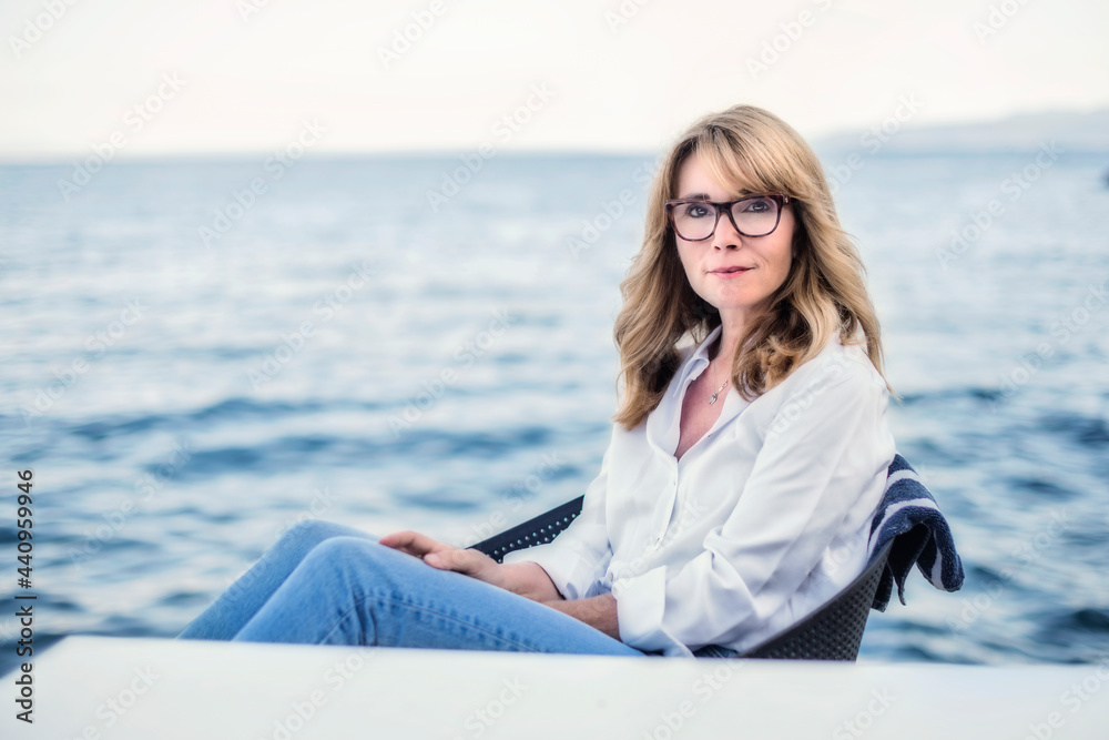 Attractive middle aged woman wearing casual clothes while relaxing by the sea
