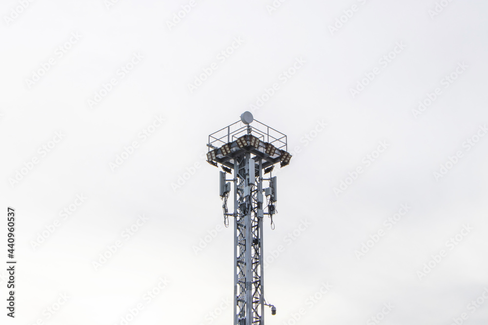 close-up photo Spotlight pole  tower 4G and 5G cellular Base Station or Base Transceiver Station above in the container yard in the port area the blue sky cloud background