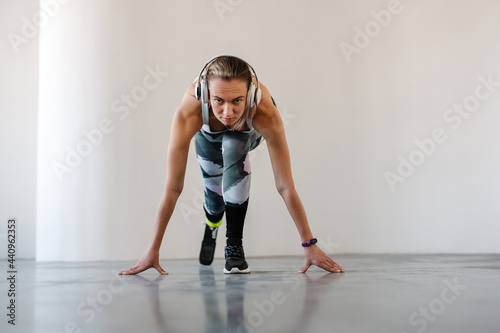 Young sportswoman with prosthesis listening music while working out