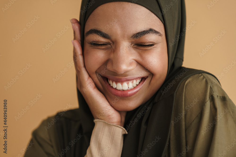 Black muslim woman in hijab posing and laughing at camera