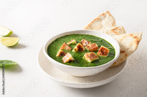 Palak Paneer with chapati on white background. Indian vegetarian cuisine made of spinach and paneer cheese. Close up. photo