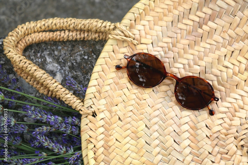 Straw bag filled with fresh lavender flowers and retrro sunglasses. Flat lay. photo