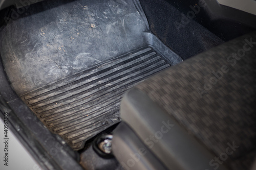 Car floor mats that are dirty with dust, dirt, sand and small rocks. which urgently needs to be cleaned to make the car look better.