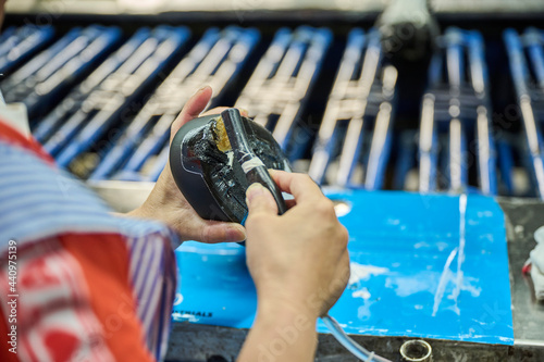 Detail of worker applying glue to the shoes sole in a production