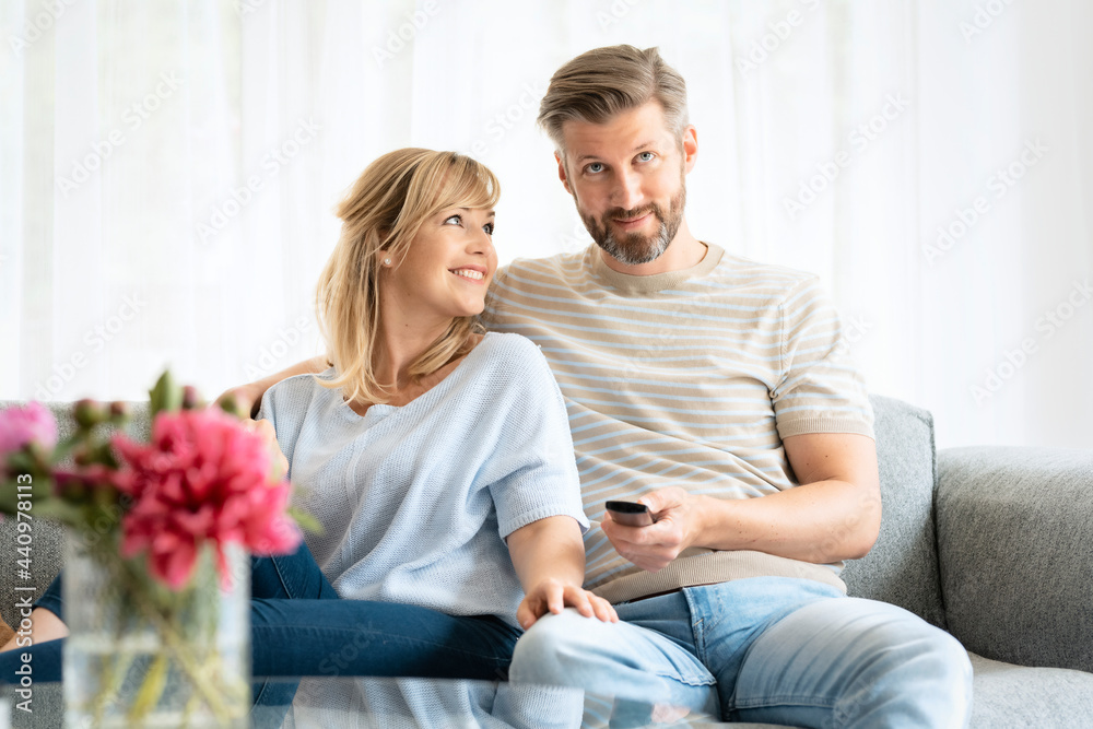 Happy couple relaxing at home and watching tv