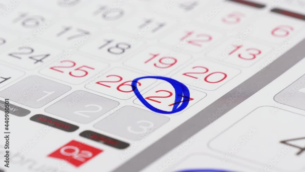 Mark date on a calendar. Hand with a felt tip pen mark on a calendar date, deadline concept