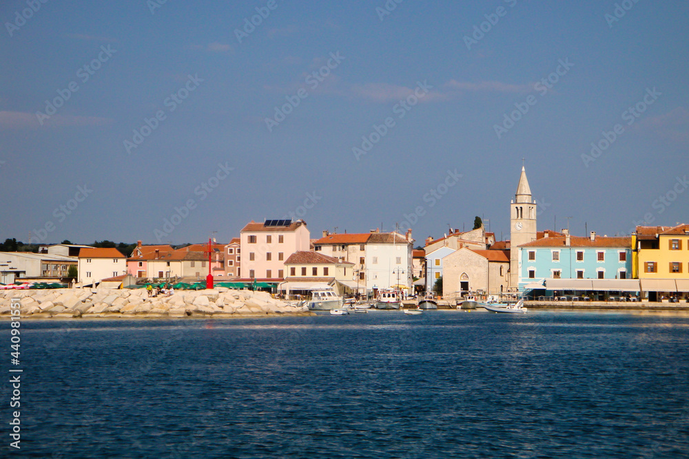Kroatien, Fazana. Blick vom Wasser auf  die idyllische Stadt  mit dem Kirchturm und den bunten Häuserfronten