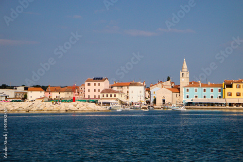 Kroatien, Fazana. Blick vom Wasser auf die idyllische Stadt mit dem Kirchturm und den bunten Häuserfronten