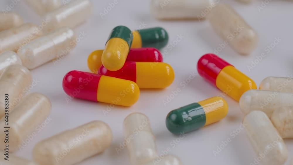 Pills, tablets, drugs, meds, medications or supplements rotating on white surface - close up. Healthcare, pharma industry, medicine, sample and pharmaceutical concept Pills, tablets, drugs, meds, medications or supplements rotating on white surface - close up. Healthcare, pharma industry, medicine, sample and pharmaceutical concept