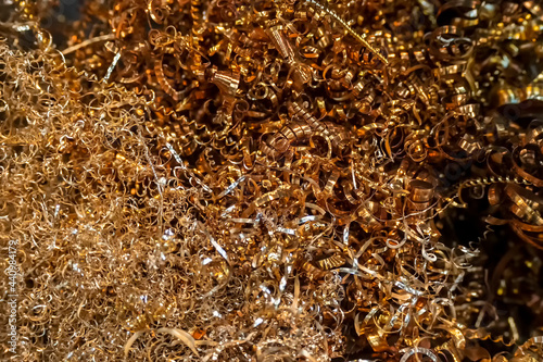 Close-up scene of brass materials scrap from turning process. The pile of lathe chips.