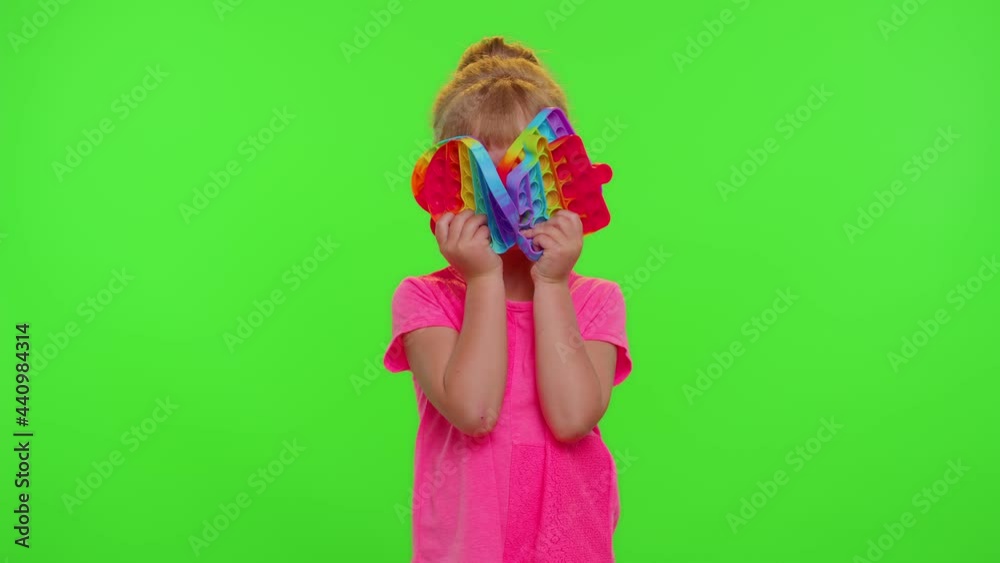 Little cute stylish child girl showing many colorful squishy silicone bubbles sensory toy. Kid playing push pop it popular educational children game. Trend 2021. Advertising, copy-space. Stress relief Little cute stylish child girl showing many colorful squishy silicone bubbles sensory toy. Kid playing push pop it popular educational children game. Trend 2021. Advertising, copy-space. Stress relief