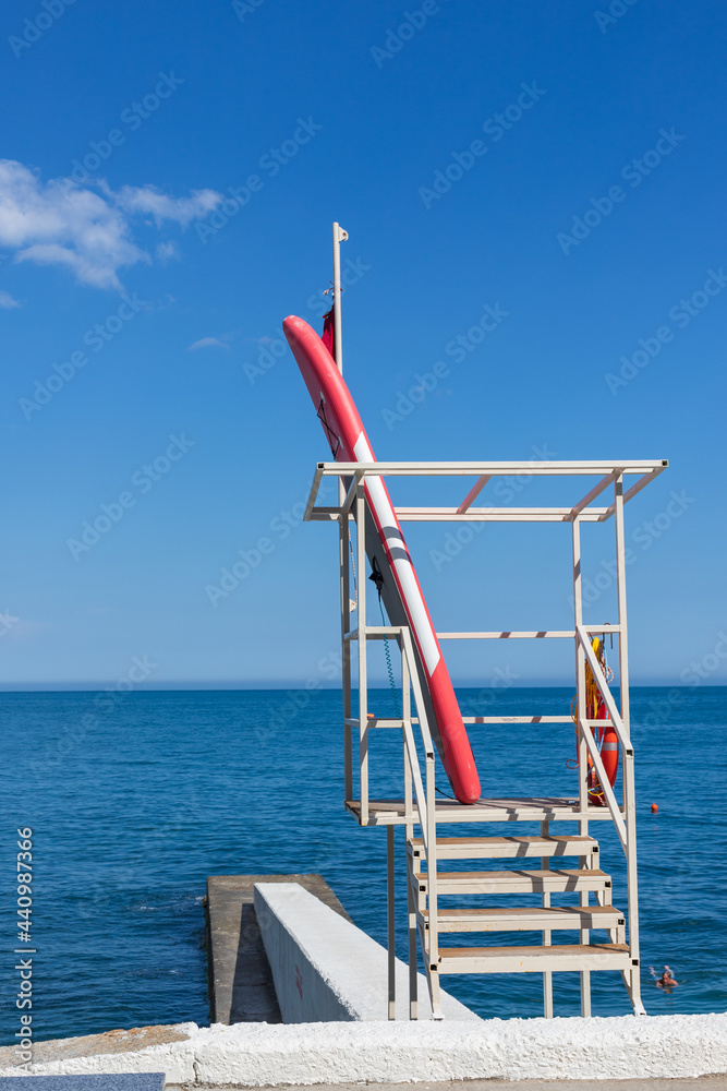 Rescue tower and boat on the pier. view of the sea coast, city beach. Vertical