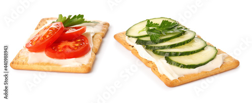 Tasty crackers with cheese, tomatoes and cucumber on white background