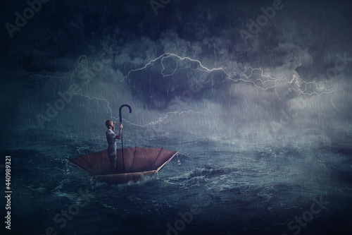 Person sailing alone the ocean on an umbrella boat, looking for shore. Surreal scene with a storm over the sea. Fantastic adventure concept. Business despair metaphor, conquering and facing adversity