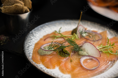 Salted smoked salmon , salt and pepper on black background