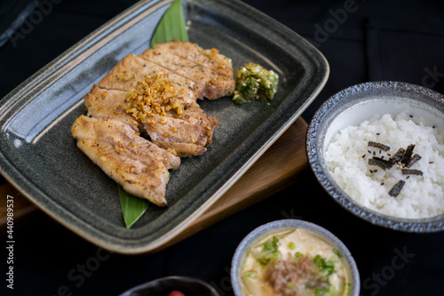 Pork Chop Kurobuta Steak set with rice, salad, miso soup, tamagoyaki and kimchi on black background - Japanese food style