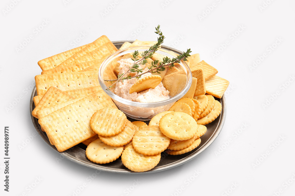 Plate with tasty crackers and sauce on light background Plate with tasty crackers and sauce on light background