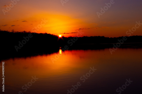 beautiful, bright, and colorful sunset over a lake on a warm summer evening. 