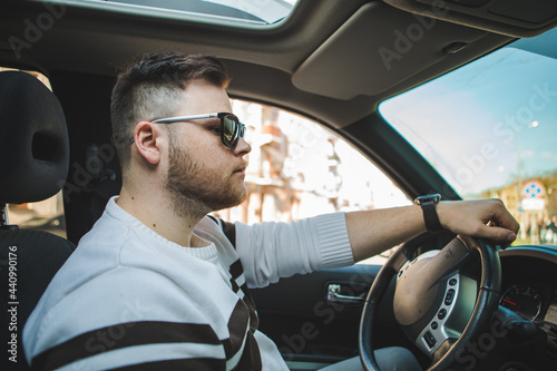strong confident man in sunglasses driving the car