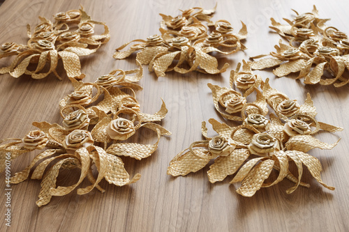 The branchs with leaves is made of straw. Straw wall decoration. The products are made of straw. Decoration of straw on a wooden background