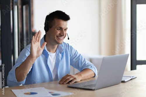 Fotografie Hiring concept, smiling young man uses laptop for online video interview, succes