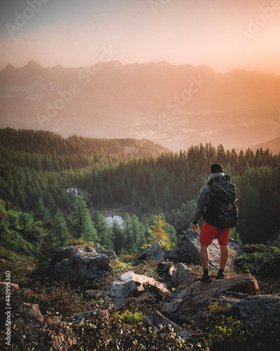 Hiker with Backpack standing on Mountain Peak - Enjoying View in the austrian alps near Schladming