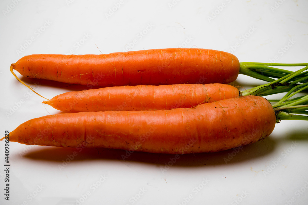 A bunch of carrots with tops, isolated on a white background A bunch of carrots with tops, isolated on a white background