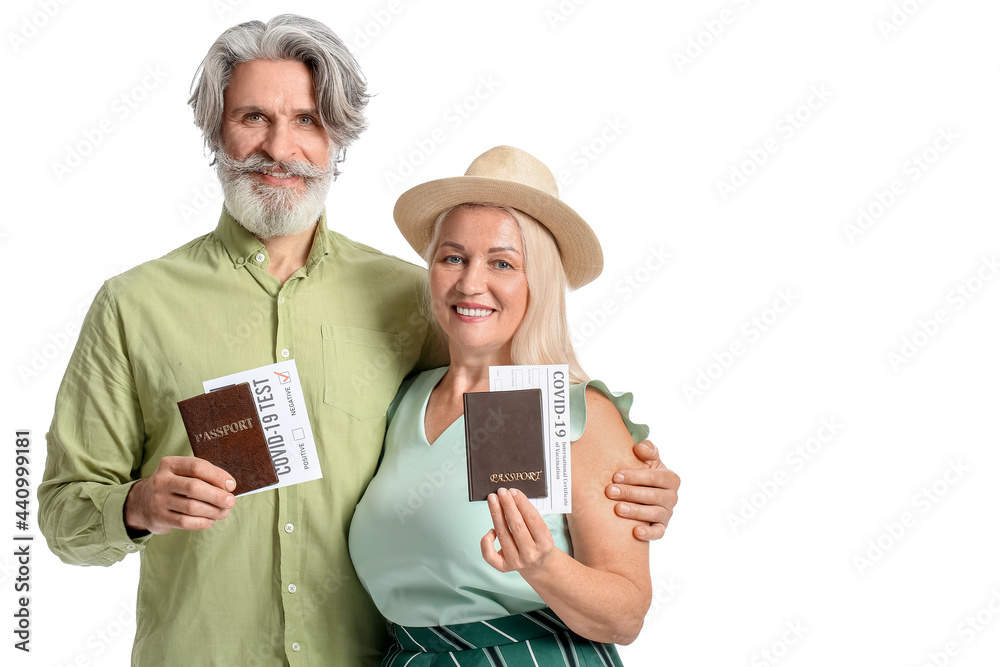 Couple of senior tourists with passports and negative covid-19 test results on white background