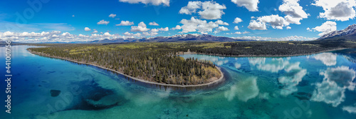 Kathleen Lake, Yukon, Canada. Taken in the summertime with stunning emerald, turquoise green reflective water with blue sky clouds and wild boreal forest. 