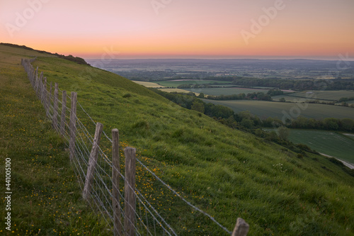 A farm fence on top of South Downs National Park overlooking the East Sussex Weald. The South Downs Way is a national trail popular with walkers located in East Sussex, South East England, UK.
