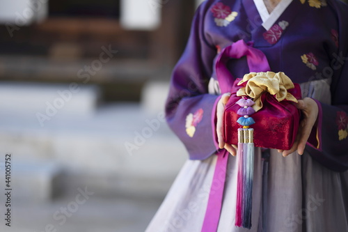 Woman in Korean traditional clothes holding traditional package