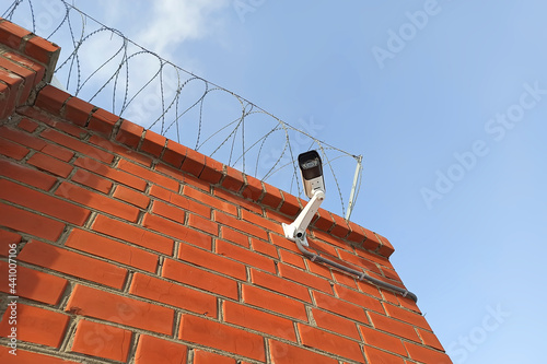 CCTV camera on a brick wall. Secured territory.