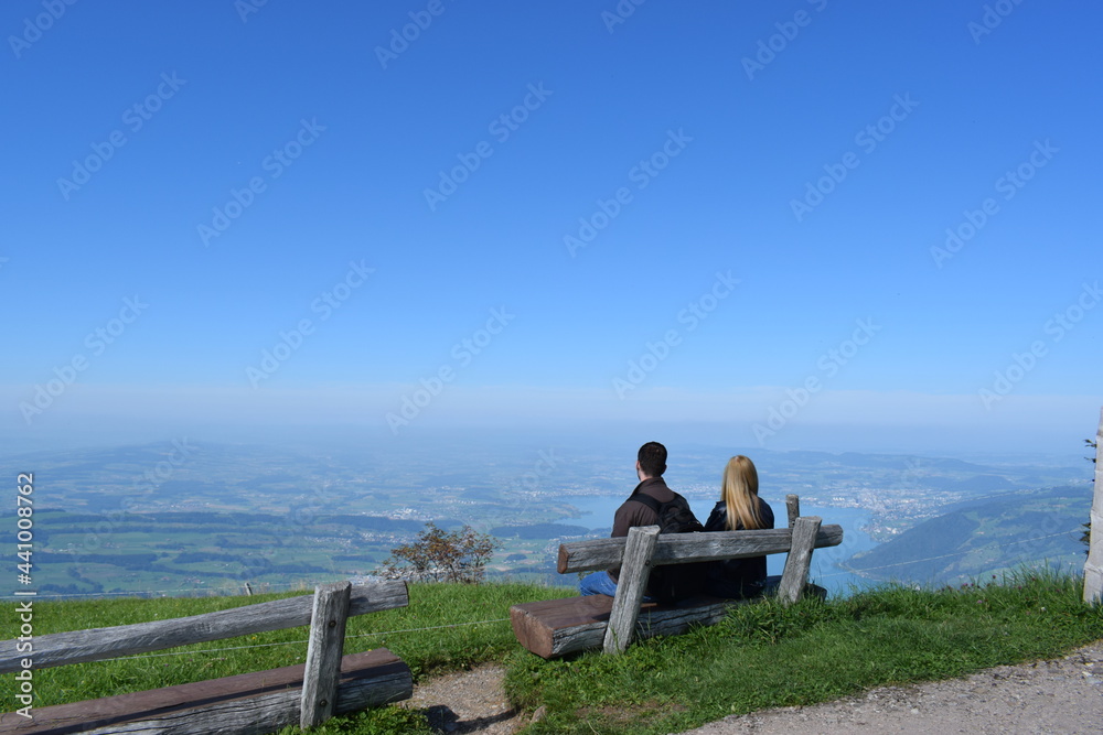 sitting on a bench on top of a mountain