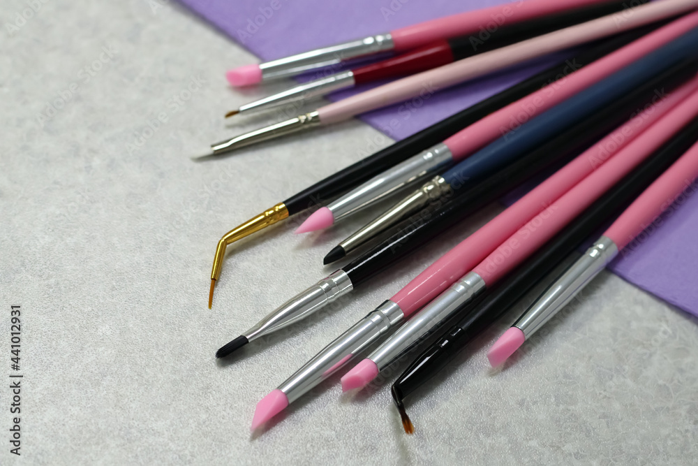Set of different dental brushes for teeth treatment on table with purple napkin, selective focus. Medical tool and equipment. Set of different dental brushes for teeth treatment on table with purple napkin, selective focus. Medical tool and equipment.