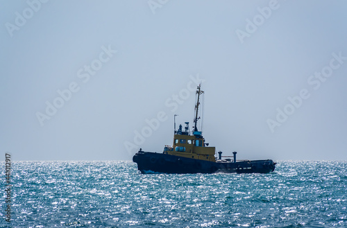 The Tug Ship is sailing on the blue sea.