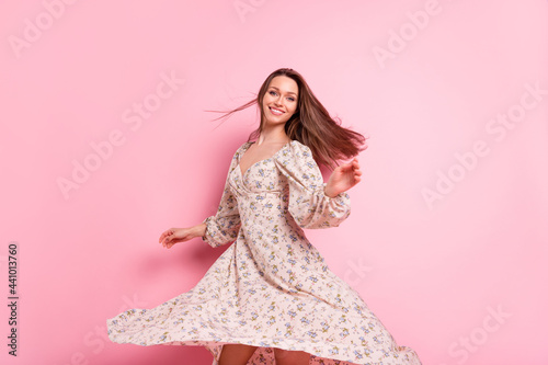 Photo portrait smiling girl dancing in printed dress on weekend summer isolated pastel pink color background