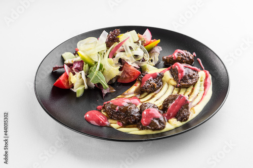 fried chicken liver with mashed potato on black plate isolated on white background